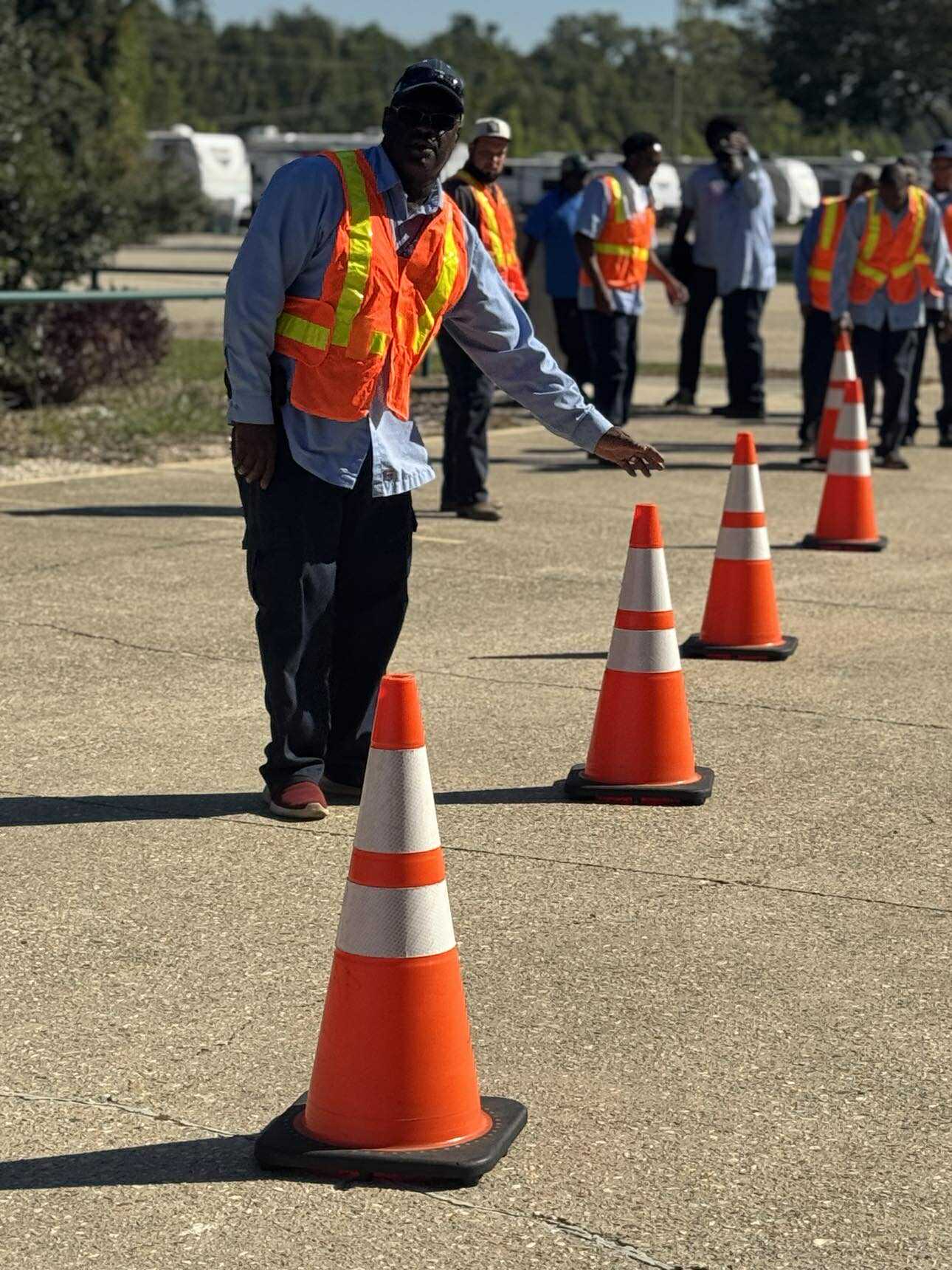 Man in vest grabbing cone